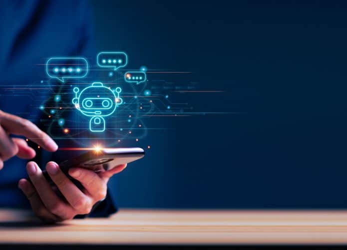 imagem mostra um homem mexendo em um celular tecnológico, com um símbolo de chatbot, associando o aparelho à inteligência artificial
