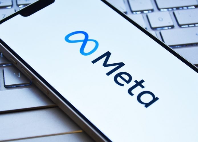 Celular com logomarca da Meta na tela colocado em cima de teclado de notebook