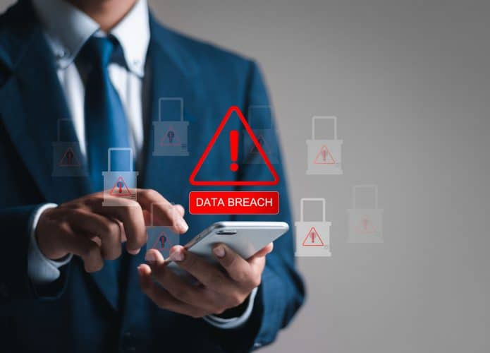 Conceito de violação de dados e ataque de hackers; empresário usa smartphone com ícone de cadeado virtual para vazamento de informações