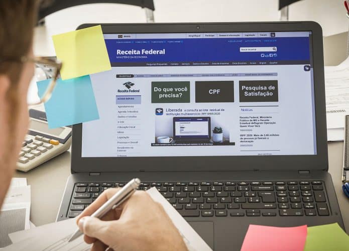 Página da Receita Federal brasileira aberta na tela do notebook em cima de um banco de escritório