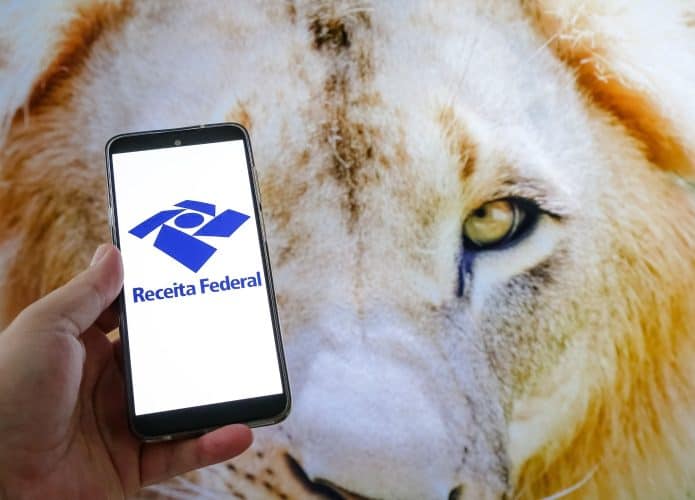 Nesta ilustração fotográfica, tela de um celular com o leão do imposto de renda federal.
