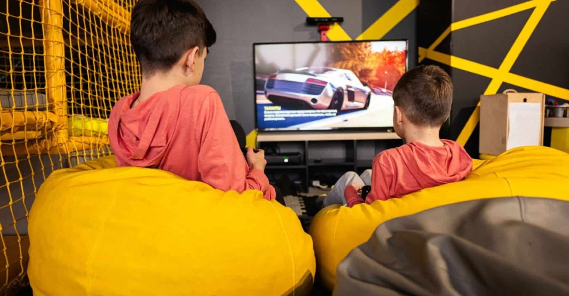 Imagem mostra duas crianças jogando videogame.
