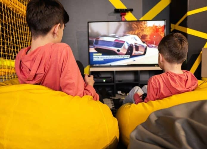 Imagem mostra duas crianças jogando videogame.