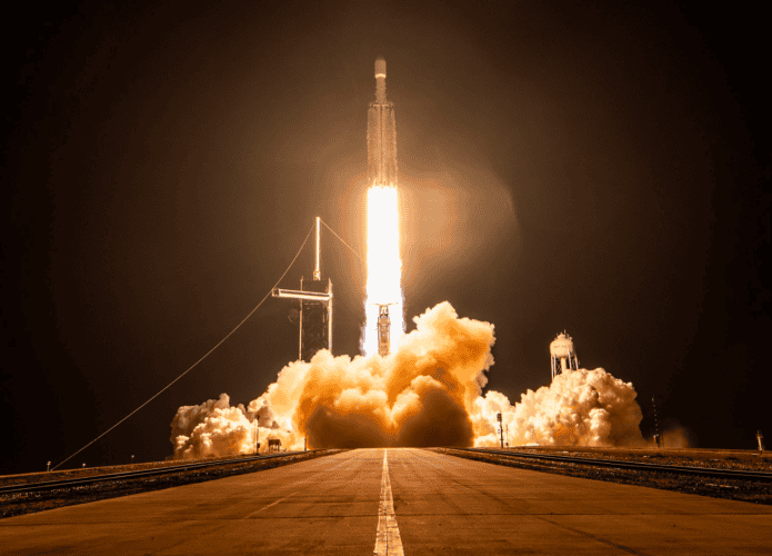 Foguete Falcon Heavy, da SpaceX, parte no céu noturno com o X-37B