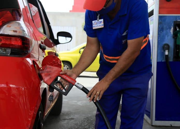 um frentista é visto durante o abastecimento de um veículo em um posto de gasolina pertencente à rede Menor Preço na cidade de Salvador.