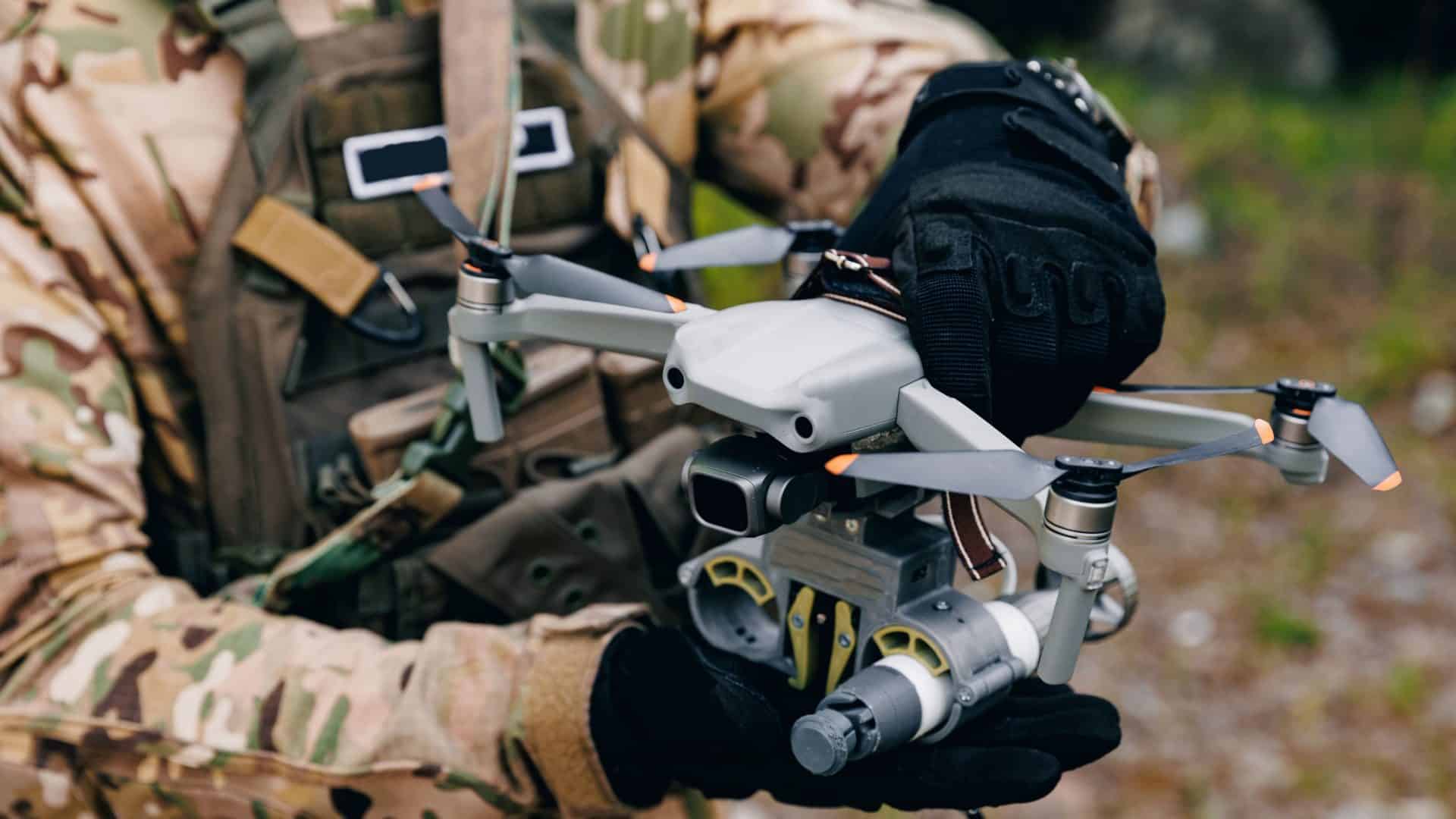 Soldado manuseando drone com as duas mãos