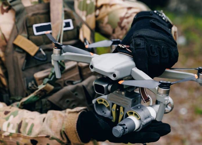 Soldado manuseando drone com as duas mãos