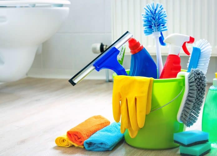 Produtos de limpeza em baldinho num banheiro