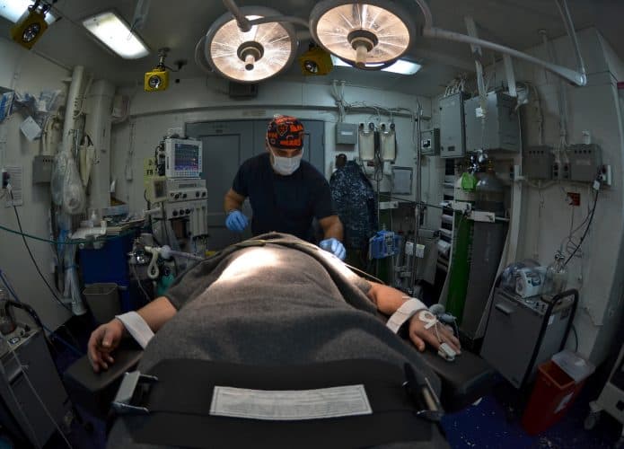 homem deitado em cama de operação recebe anestesia geral
