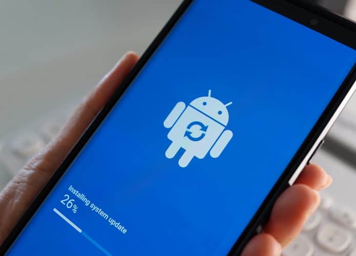 Pessoa segurando um smartphone com Android que está sendo atualizado