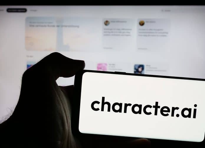Pessoa segurando smartphone com logotipo da Character Technologies Inc. (Character.ai) na tela em frente ao site. C