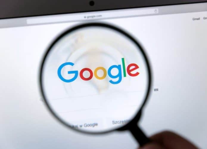 Lupa destacando o logo do Google em uma tela de computador