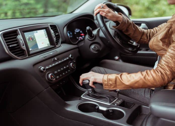Imagem mostra motorista mulher dirigindo com o volante do lado direito (mão inglesa)