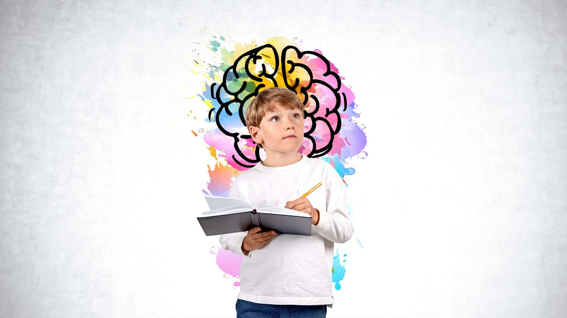 Imagem mostra um menino segurando um lápis e um caderno, em um fundo branco com ilustração colorida de um cérebro
