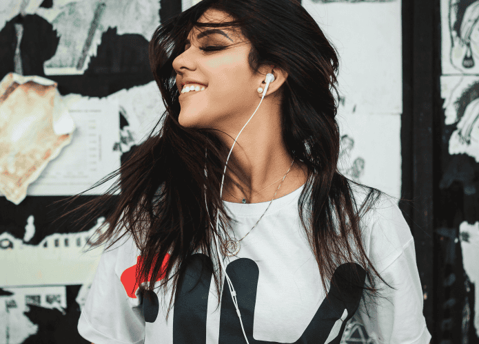 Mulher ouvindo à rádio pelos fones de ouvido e celular