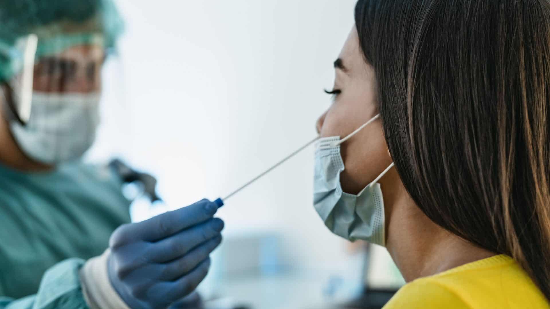 Médico realiza teste de covid-19 com cotonete em mulher