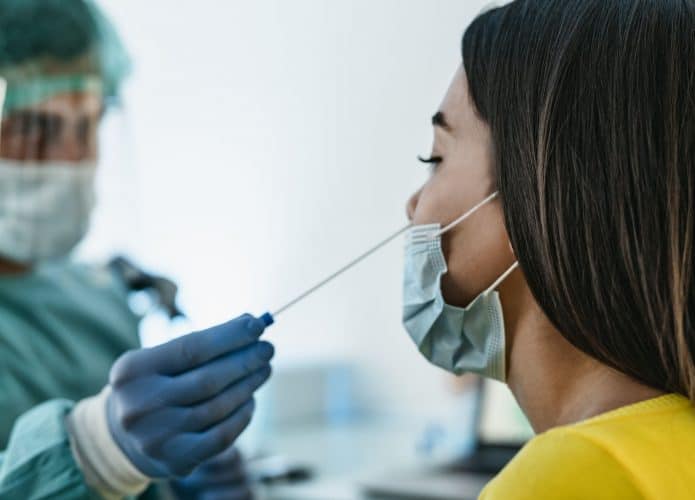 Médico realiza teste de covid-19 com cotonete em mulher