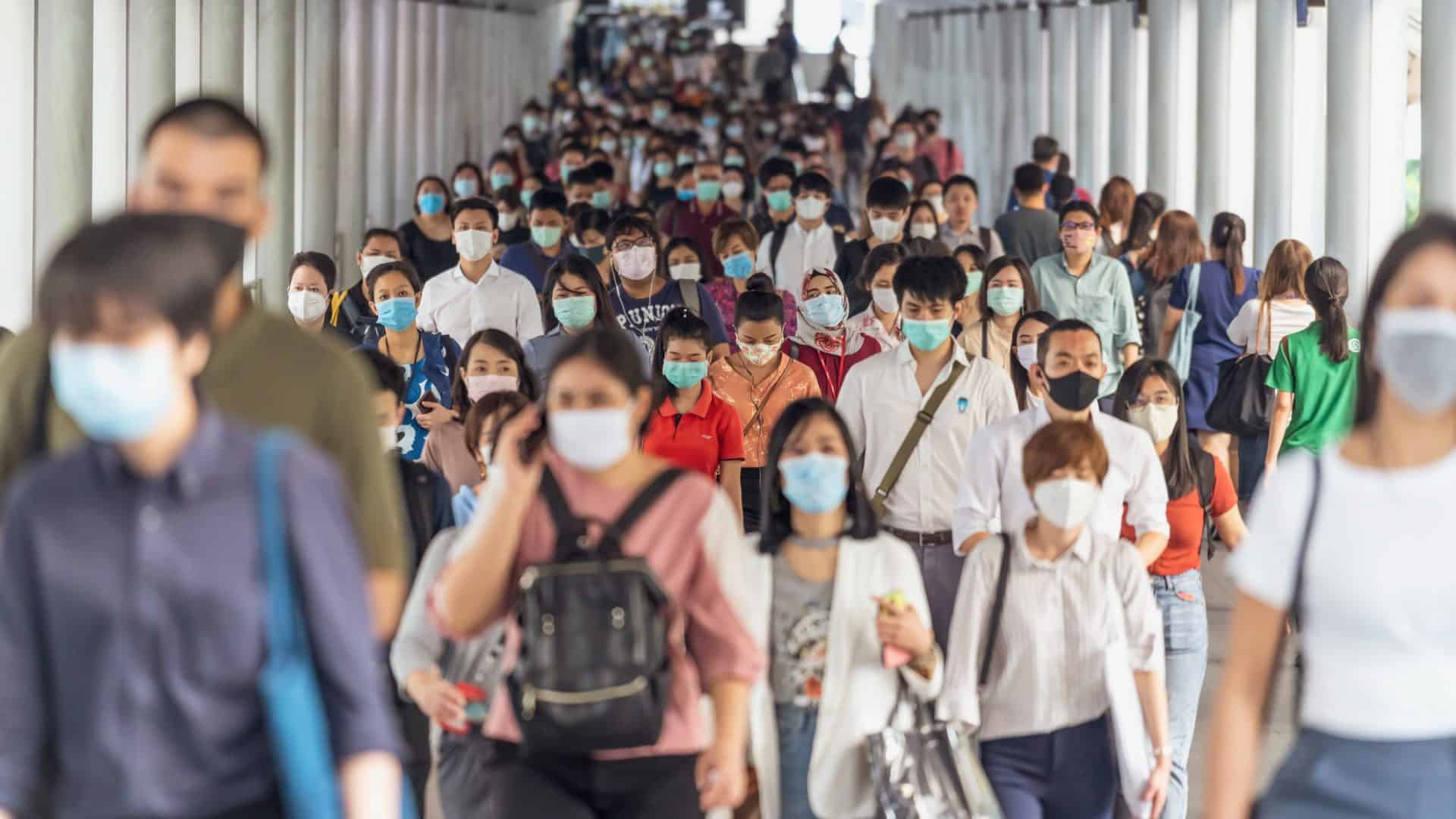 Multidão de pessoas com máscaras no início da pandemia do COVID-19