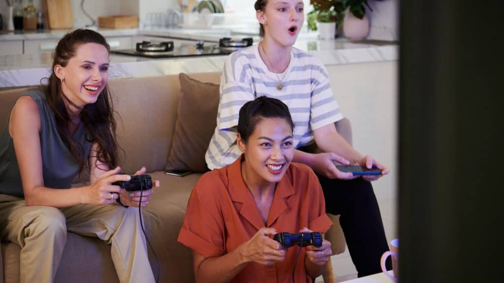 Grupo de amigos jogando videogame na sala de estar de casa