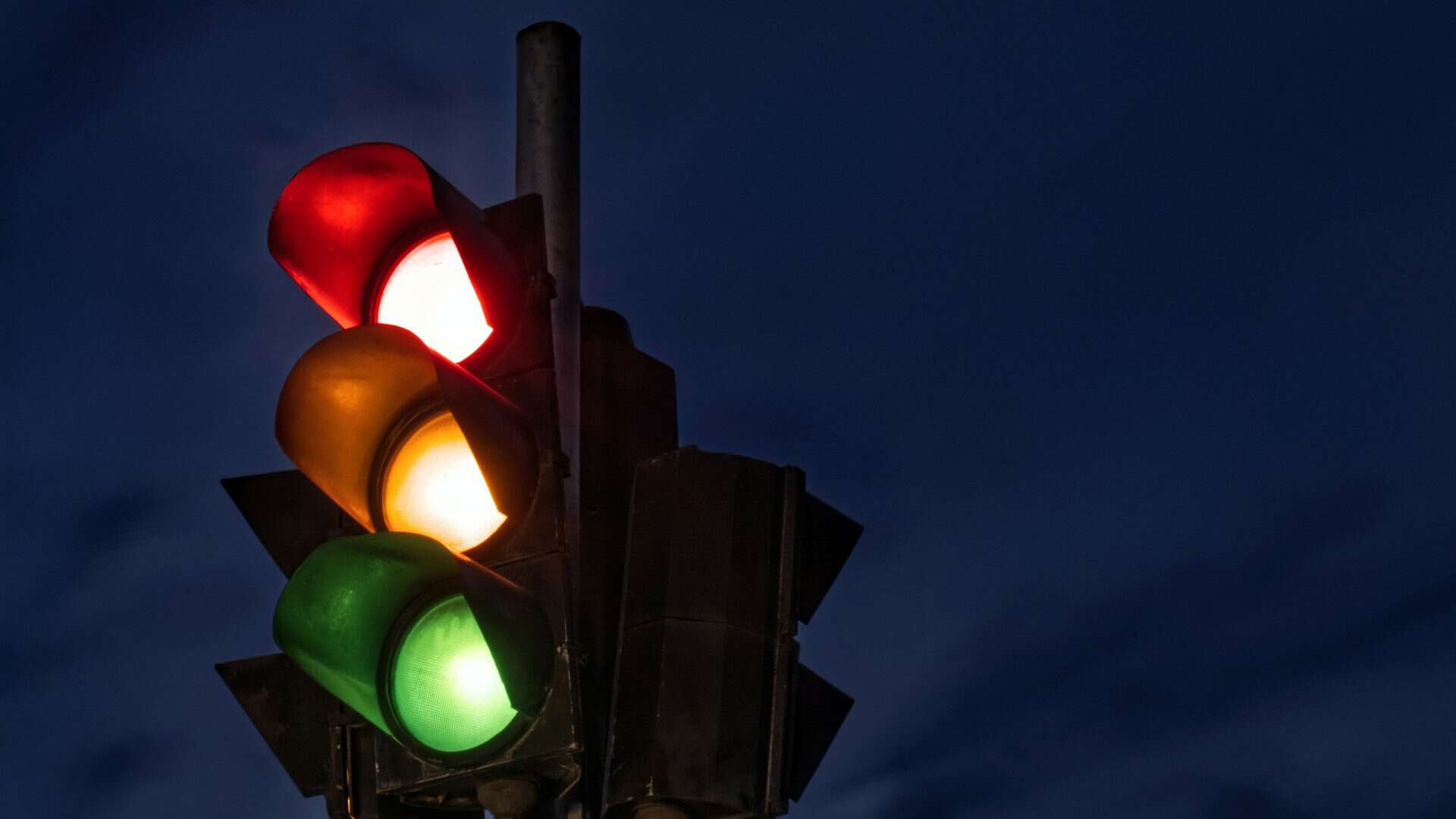 Luzes acesas de um semáforo (vermelha, amarela e verde)