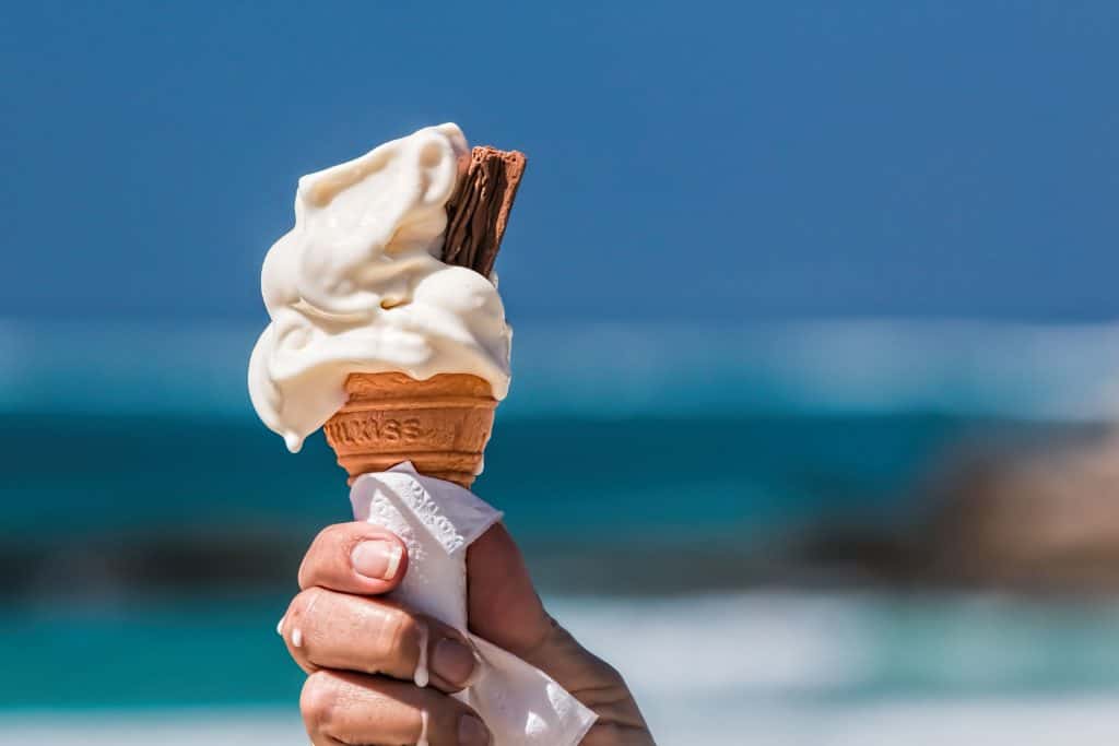 Imagem mostra mão segurando um sorvete que está derretendo com alto nível de calor