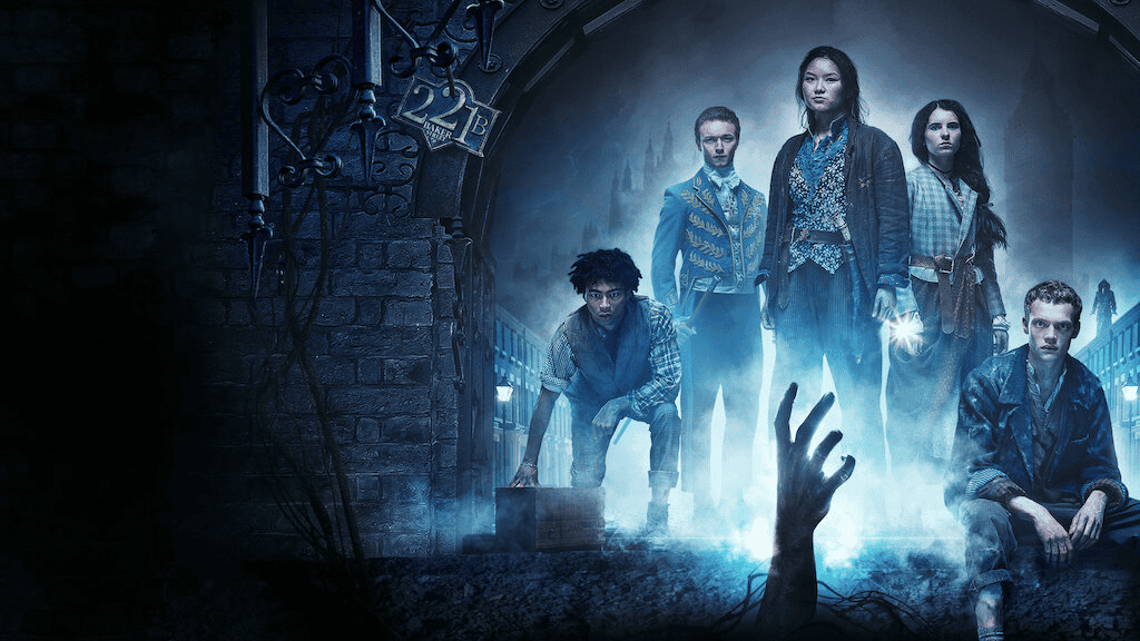 Arte promocional da série "The Irregulars" (2021), da Netflix. Um grupo de jovens vestidos com trajes vitorianos está sob um arco sombrio com o número 221B, referência ao endereço de Sherlock Holmes. A cena tem tons azulados e uma mão espectral surge do chão, criando uma atmosfera de mistério e sobrenatural.