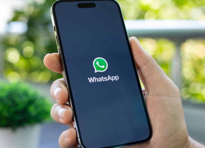 Logo do WhatsApp em um smartphone segurado por uma pessoa