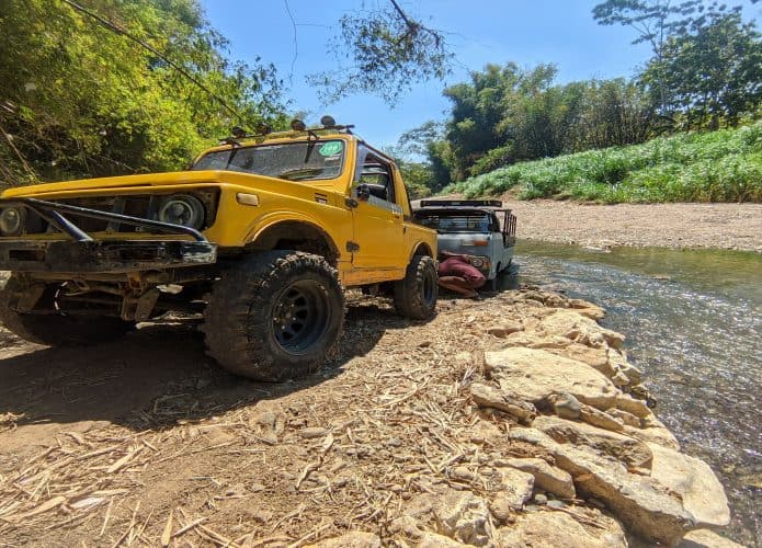 Jjipe ​​amarelo, modelo de carro com tração 4x4 puxa um caminhão que está preso na margem do rio Oya, Gunungkidul