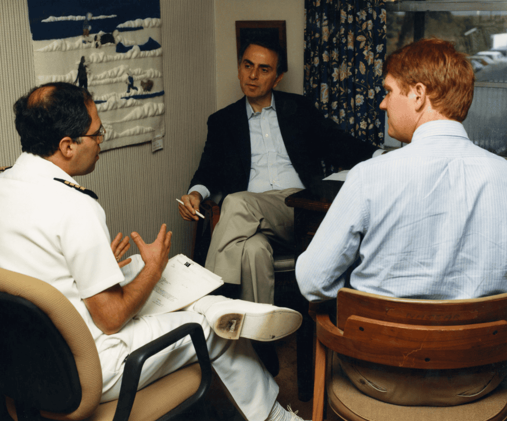 Carl Sagan reunido com dois funcionários do CDC em 1988, durante uma visita ao campus Roybal, em Atlanta.