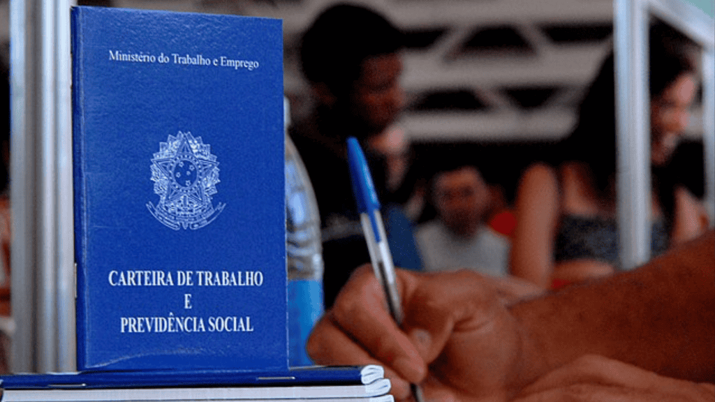 Carteira de trabalho e mão segurando caneta