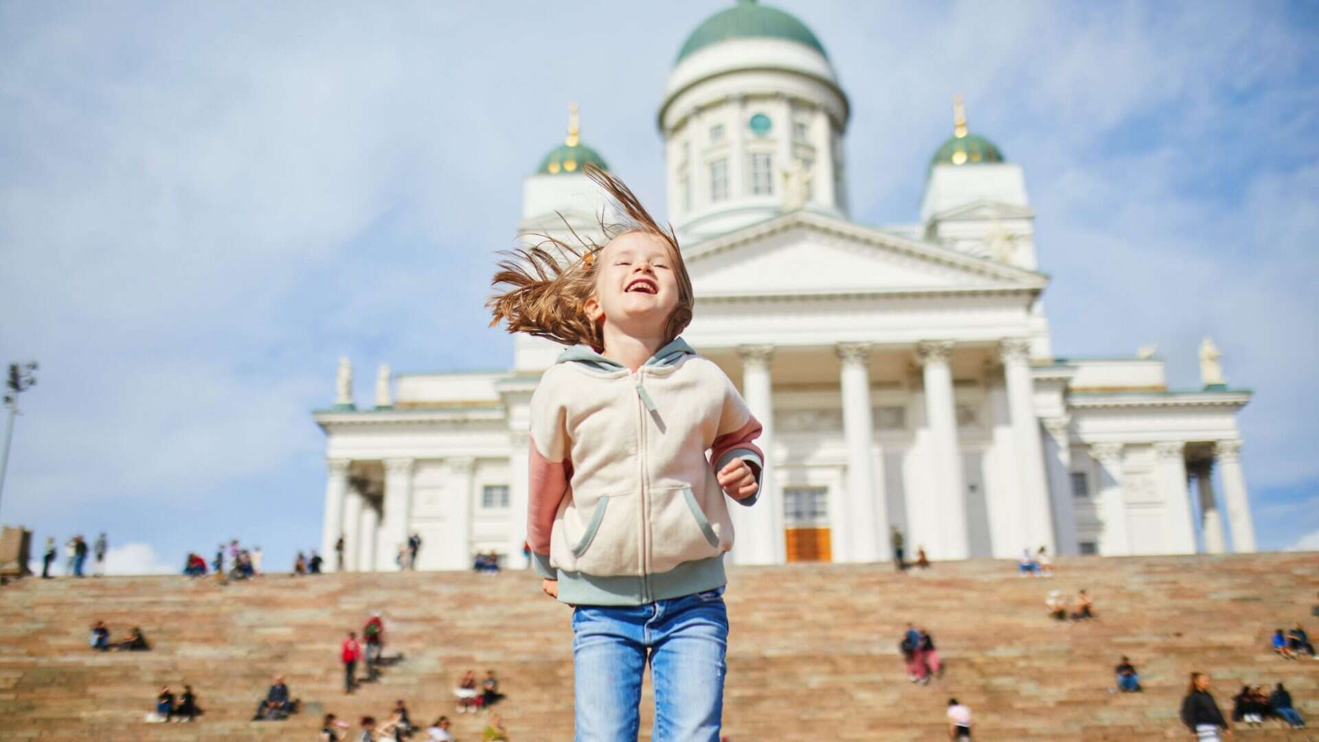 Adorável menina pré-escolar perto da Catedral de Helsinki (Helsingin tuomiokirkko) em Senaatintori em Helsinki, Finlândia