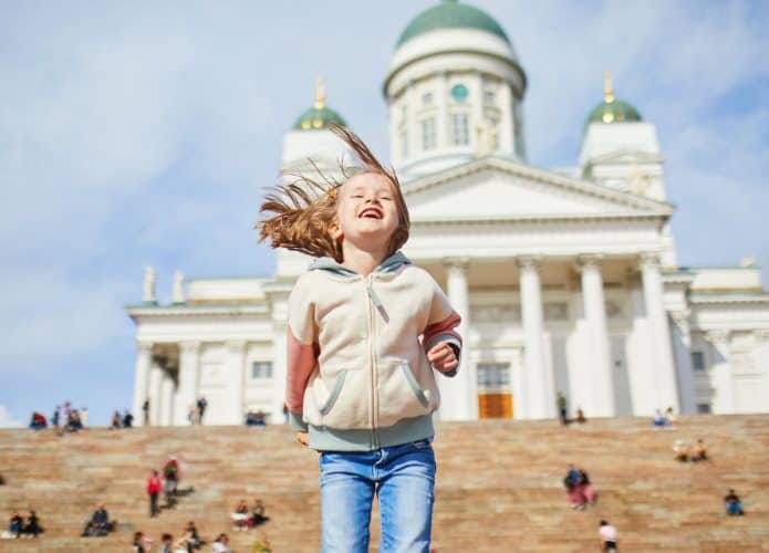 Adorável menina pré-escolar perto da Catedral de Helsinki (Helsingin tuomiokirkko) em Senaatintori em Helsinki, Finlândia