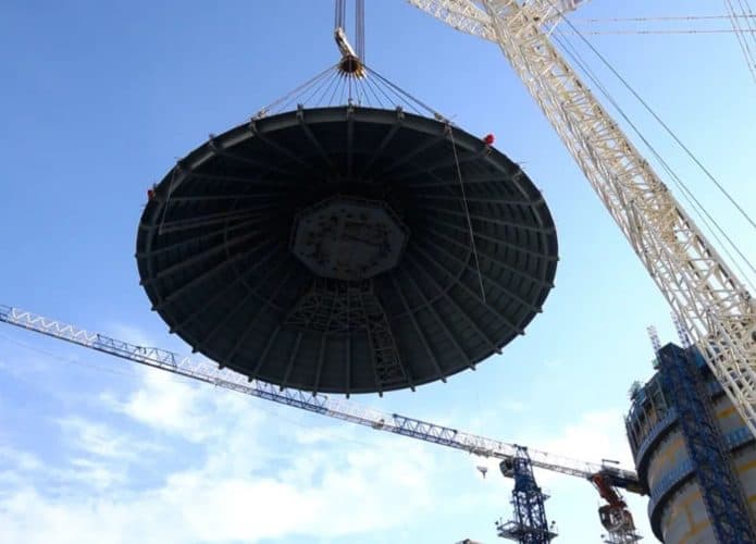 Domo de aço gigante sendo içado para selar unidade em usina nuclear na China