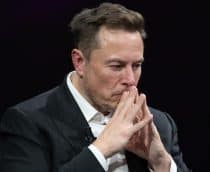 Elon Musk com as mãos na frente do rosto e expressão preocupada