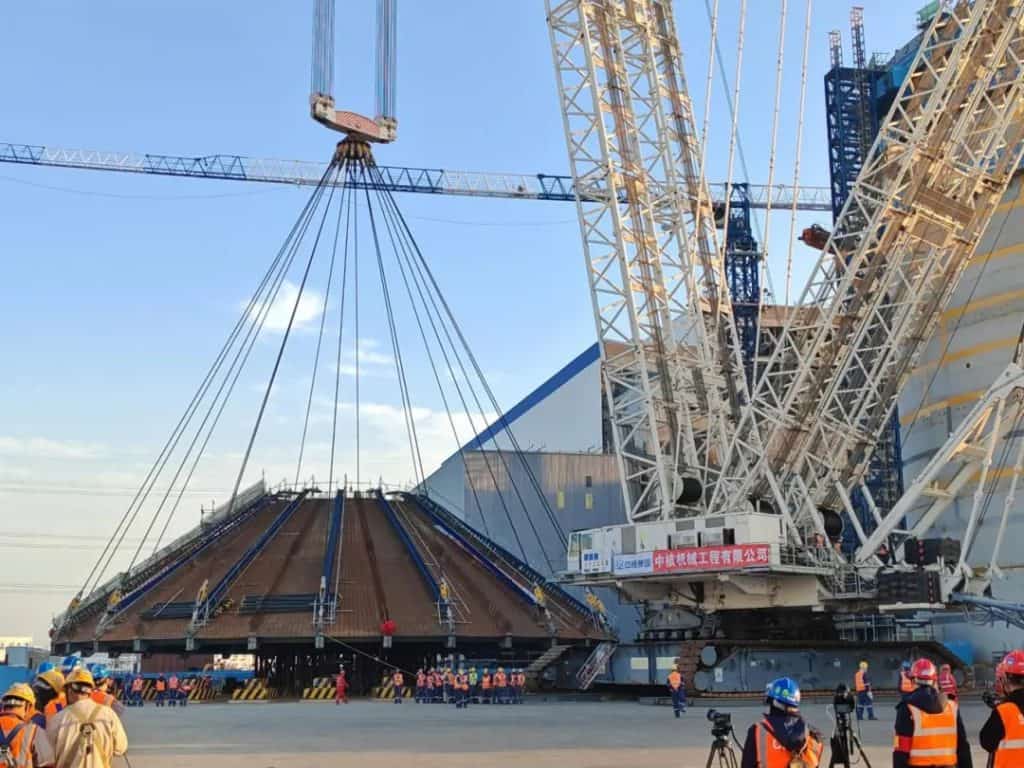 Domo de aço gigante próximo do chão enquanto é içado para selar unidade em usina nuclear na China