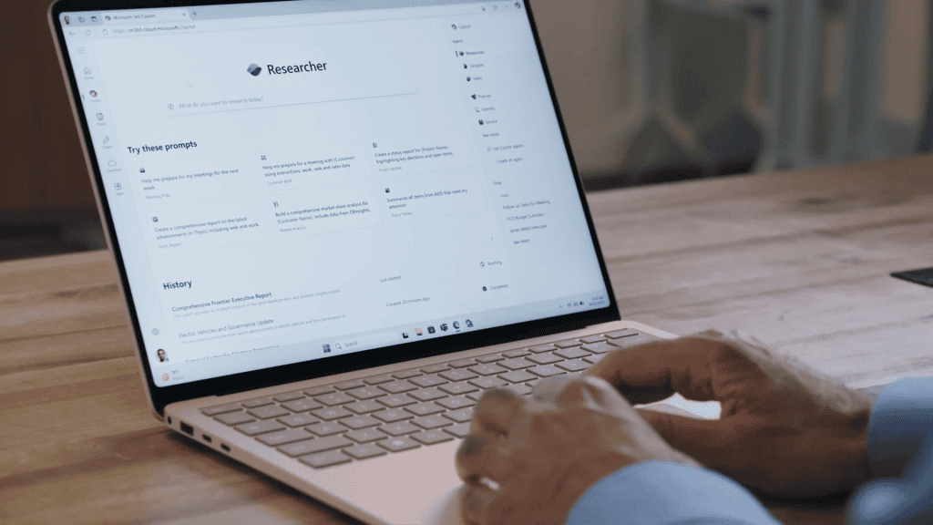 Homem teclando em notebook enquanto usa agente de IA Researcher do Microsoft 365 Copilot