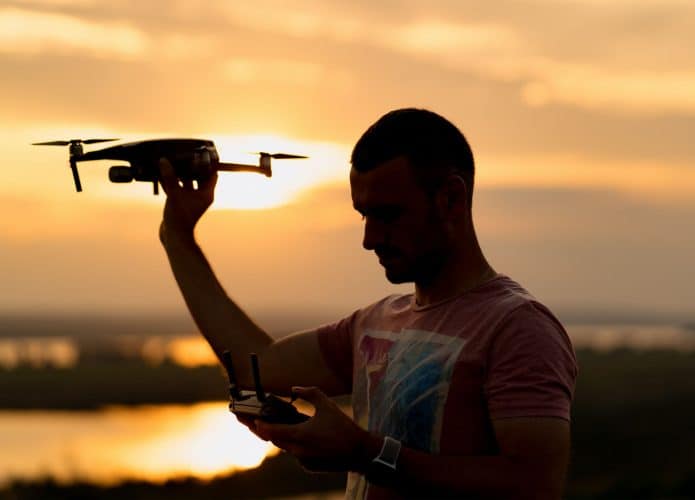 Pessoa na sombra segurando um drone