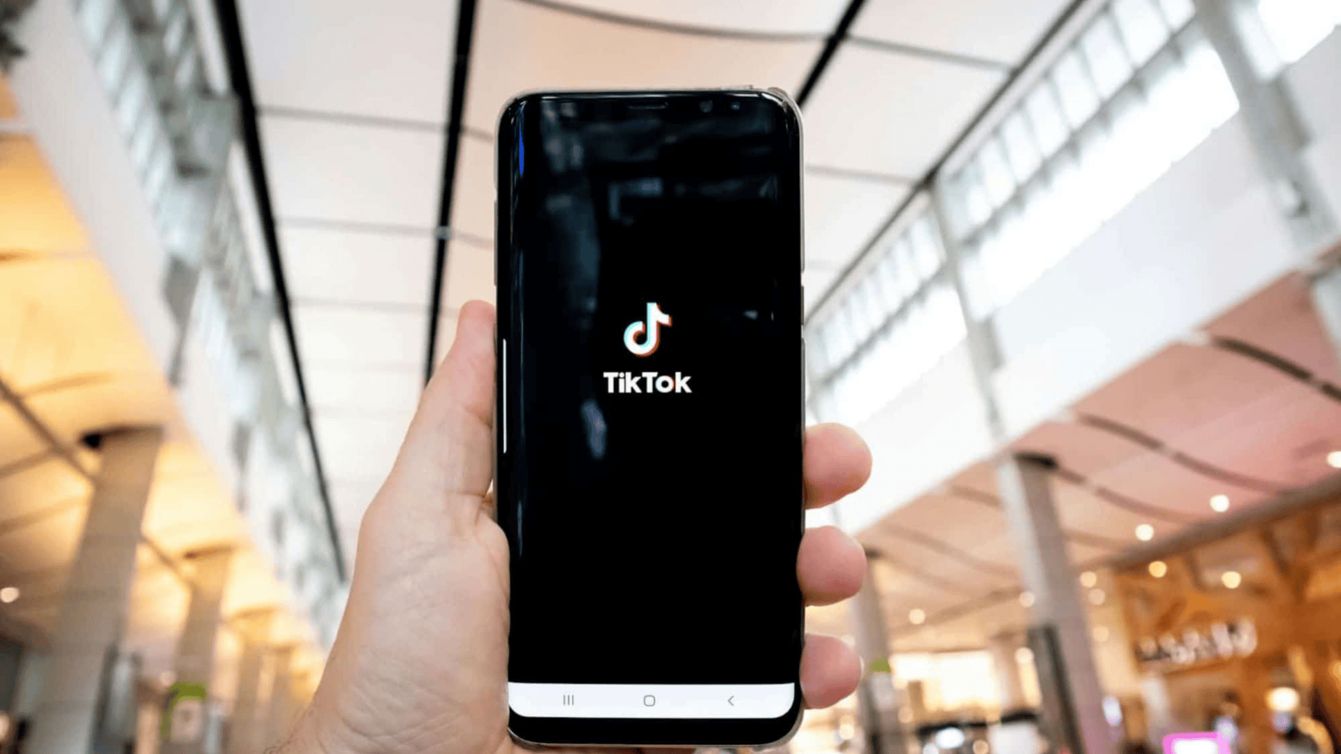 Pessoa segurando o celular enquanto o TikTok abre