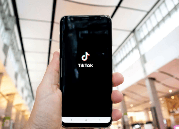 Pessoa segurando o celular enquanto o TikTok abre