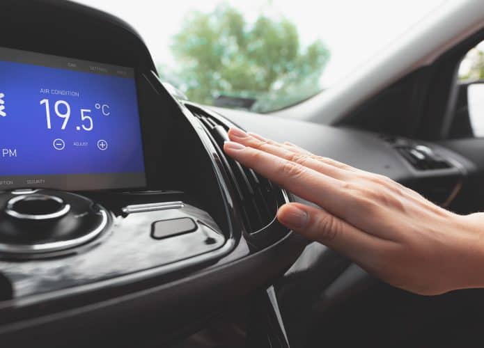 Mão de motorista ajusta ar ventilação de ar condicionado no carro