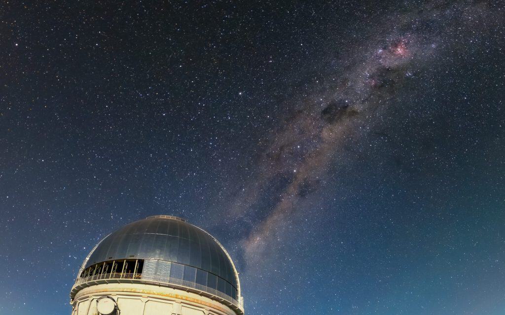 A Via Láctea brilhando acima do Telescópio Víctor M. Blanco de 4 metros (que foi usado na descoberta da galáxia) no CTIO - CTIO/NOIRLab/NSF/AURA/D. Munizaga