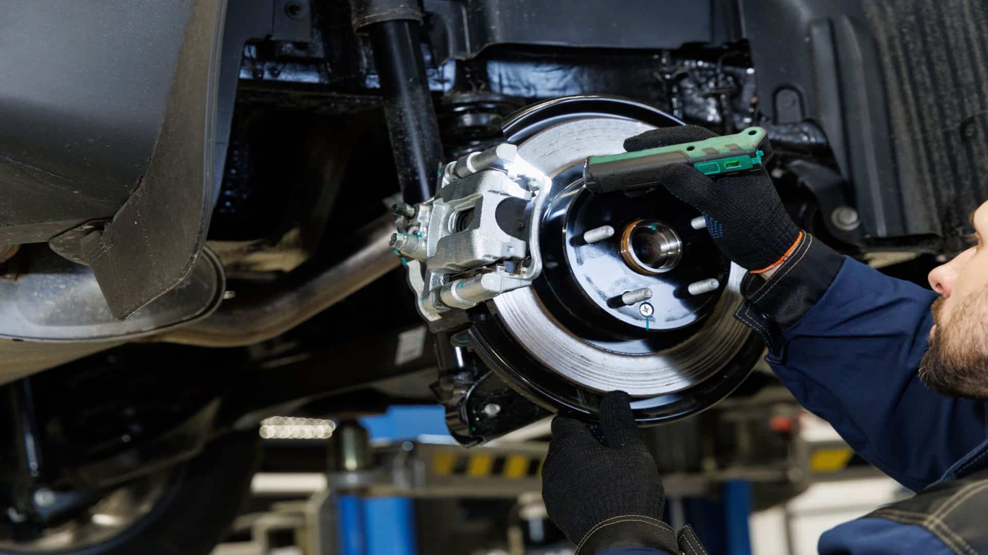 Mecânico em uma oficina mecânica diagnostica se há problema no sistema de freio de um carro