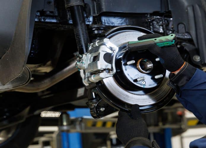 Mecânico em uma oficina mecânica diagnostica se há problema no sistema de freio de um carro