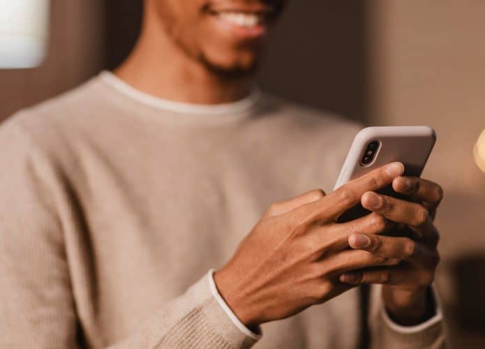 homem segurando o celular enquanto sorri