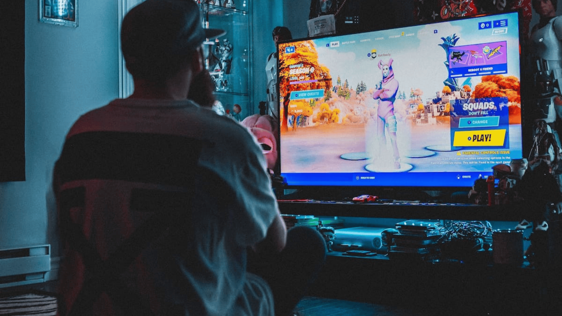 Pessoa jogando Fortnite em frente a televisão