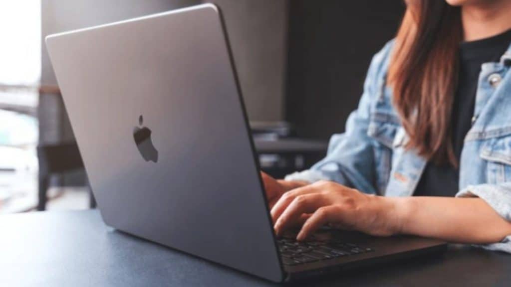 mulher em uma mesa usando macbook