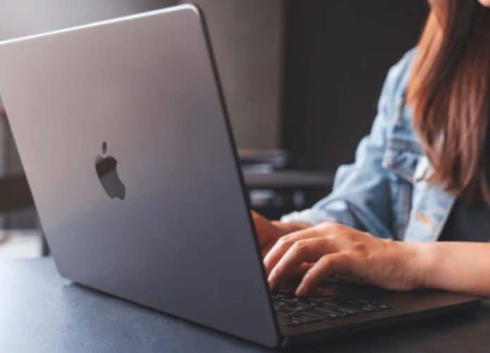 mulher em uma mesa usando macbook