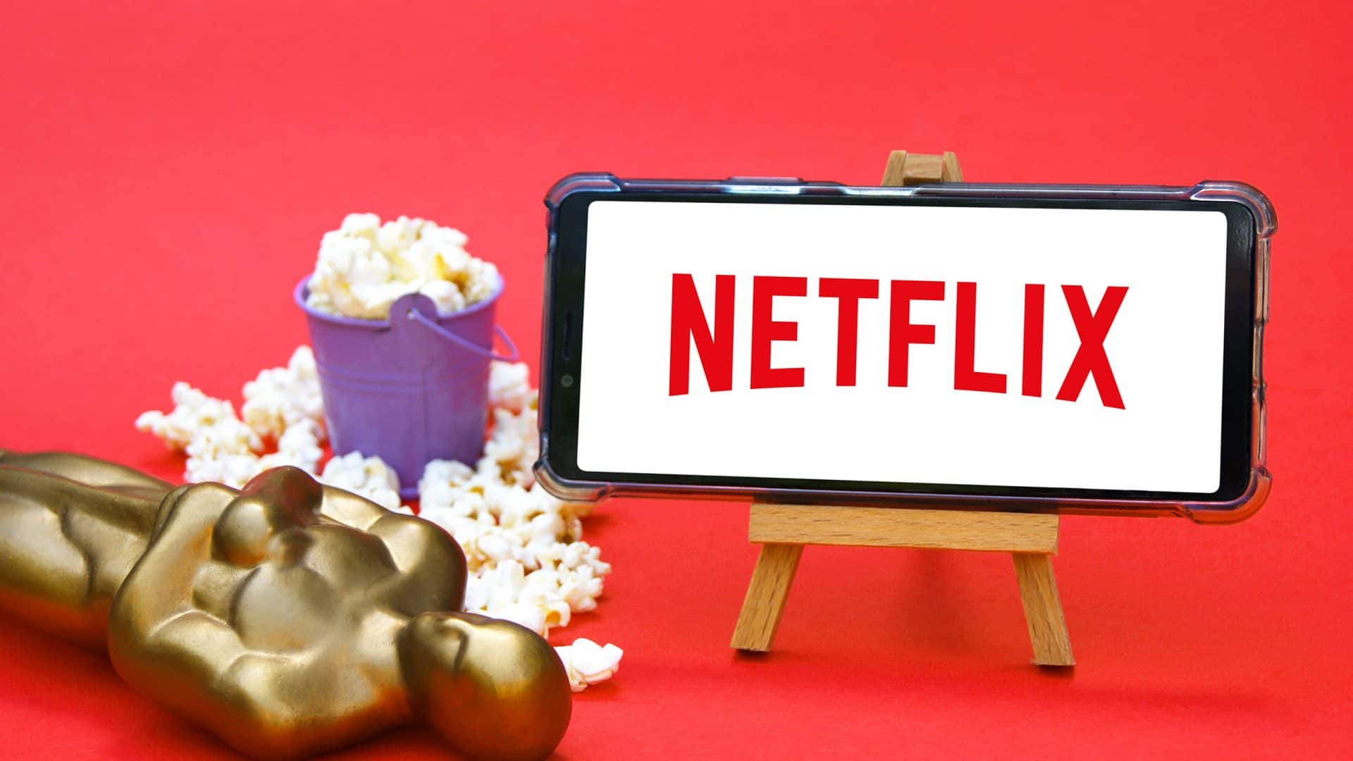 Estatueta do Oscar ao lado de um smartphone com o logo da Netflix
