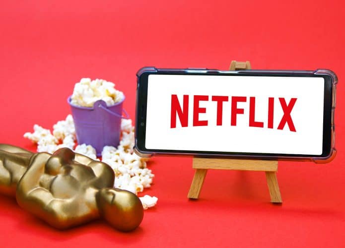 Estatueta do Oscar ao lado de um smartphone com o logo da Netflix