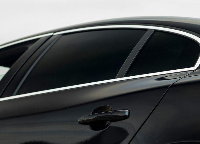 Carro preto com detalhe de pelíclula (Insulfilm) muito escura em vidro traseiro